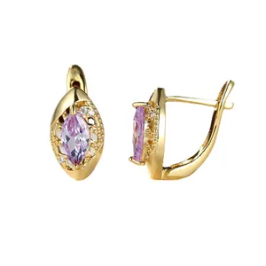 Boucles d'oreilles dorées avec zircon violet marquise et cristaux blancs sur fond blanc