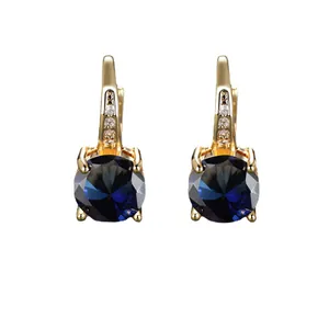 Eleganti orecchini dorati con grandi pietre blu rotonde e cristalli brillanti incastonati