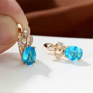 Makroaufnahme von ovalen himmelblauen Edelsteinohrringen mit Champagnervergoldung und Zirkonia