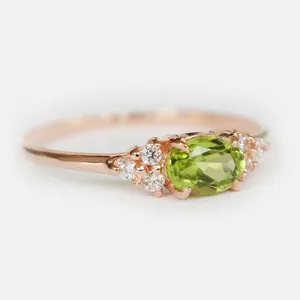 Dettaglio macro di peridoto ovale e zirconi micro-pave su anello in oro rosa