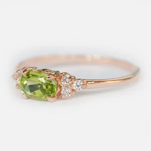 Dettaglio macro di peridoto ovale incastonato in oro rosa con micro diamanti fini