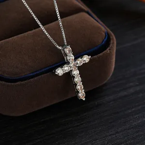 Dettaglio di una collana con ciondolo a croce d'argento con zirconi champagne brillanti