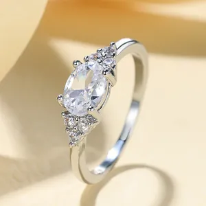 Elegante anello in argento con grande pietra ovale e piccoli zirconi laterali a grappolo