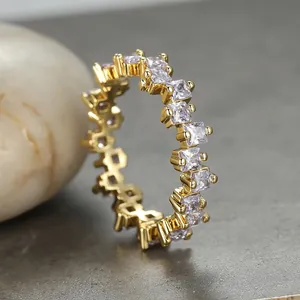 Macro side view of gold-plated eternity ring with square purple zircon stones