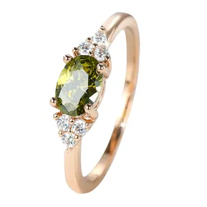 Elegante anello in oro rosa con peridoto ovale centrale e accenti di zirconi micro