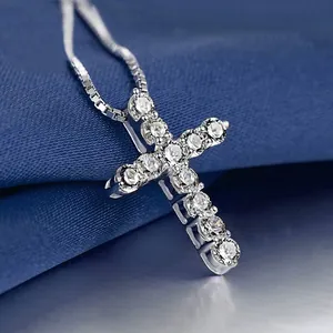 Dettaglio del ciondolo a croce in argento con zirconi blu e catena a maglia box