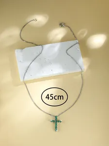 Dettaglio della collana in argento da 45cm con pendente a croce e zirconi verdi