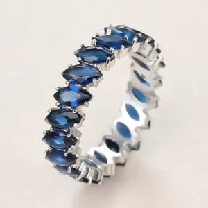 Detailed macro view of marquise-cut blue zircon eternity ring in silver setting