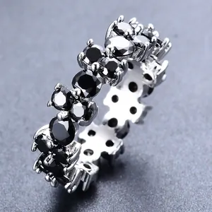 Macro-opname van een zilveren ring met rondom gezette zwarte ronde edelstenen in klauwzetting