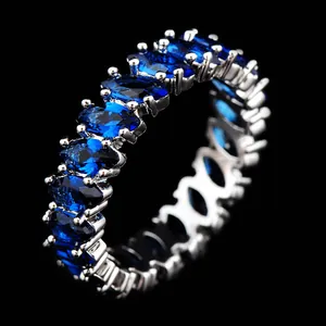Macro view of blue oval-cut cubic zirconia stones on silver eternity ring band