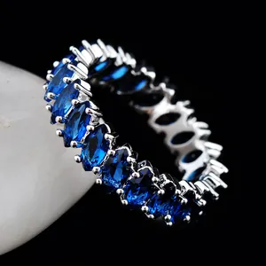 Macro shot of marquise-cut blue zircon eternity ring with silver claw-setting detail