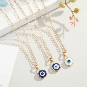 Detailed view of three gold evil eye necklaces with concentric blue and white pendants