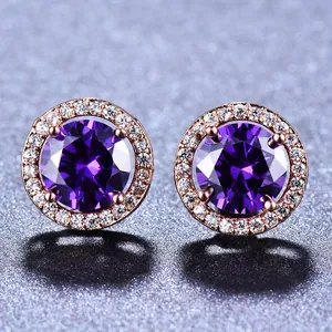Vue macro de boucles d'oreilles or rose avec gemme violette et pavage en zircon