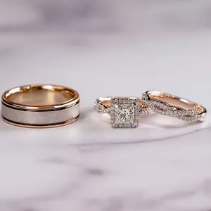 Détail de bagues de mariage en or rose et argent avec diamant taille princesse sur marbre
