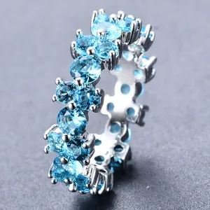 Macro-opname van een zilveren ring met lichtblauwe zirkonia in een klauwzetting