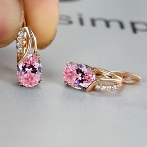 Elegant rose gold huggie earrings with oval pink zircon and small white crystals