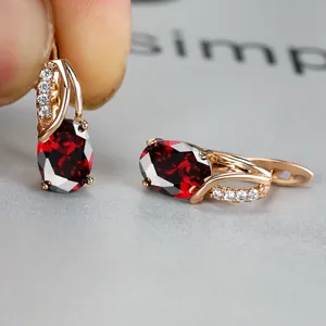 Elegant rose gold hoop earrings featuring an oval red gemstone and zircon accents