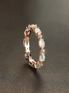 Detailed macro view of gold plated oval white opal ring with small accent stones