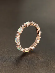 Macro detail of oval opal stones and sparkling diamonds on a rose gold band ring