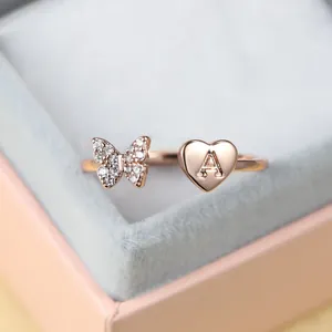 Détail de la bague en or rose avec papillon en zircons et breloque cœur lettre A