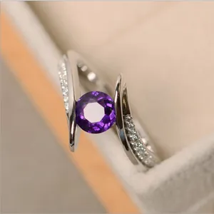 Makro-Detail des Silberrings mit rundem lila Edelstein und Zirkonia-Akzenten