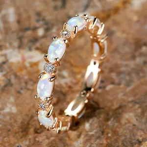 Elegant rose gold ring featuring oval white opals and sparkling cubic zirconia stones