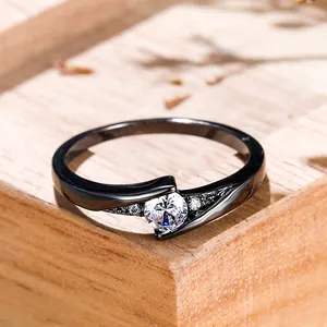 Elegant black plated ring with central cubic zirconia on a natural wooden block