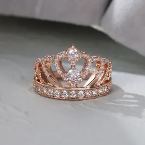 Détail d'une bague couronne en or rose avec deux pierres centrales et pavé de cristaux