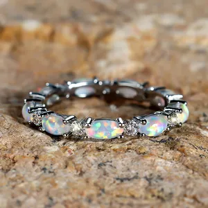 Elegant gold eternity ring with oval white opals and sparkling zircon accents
