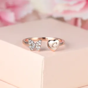 Détail de la bague en or rose avec papillon en cristal et lettre C gravée cœur