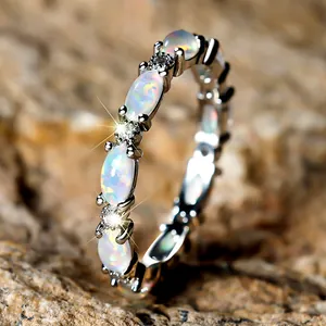 Elegant silver eternity ring featuring oval white opals and sparkling accent stones