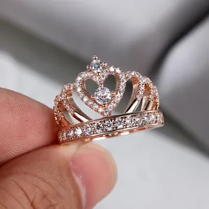Détail macro d'une bague couronne en or rose sertie de zircons blancs en forme de cœur