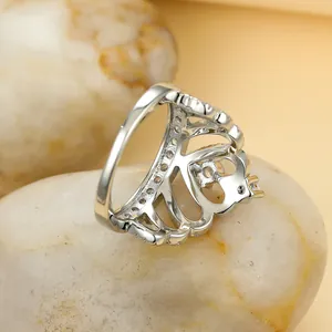 Détail d'une bague couronne en argent avec zircons étincelants sur des galets naturels