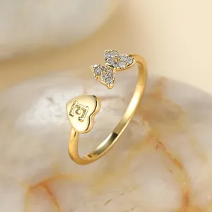 Détail de la bague papillon dorée avec lettre F en cœur et pavé de zircons fins