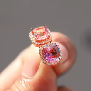 Macro shot of rose gold halo earrings with pink and purple gradient cushion-cut gemstones