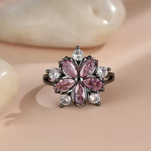 Macro shot of sakura pink zircon flower ring with black gold plating on smooth stones