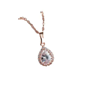 Elegant rose gold necklace featuring a pear-cut white crystal drop pendant with halo stones