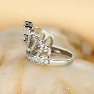 Gros plan d'une bague couronne en argent avec détails en cœur et zircons blancs scintillants