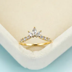 Dettaglio anello a corona in oro con pietre marquise in scatola per gioielli beige