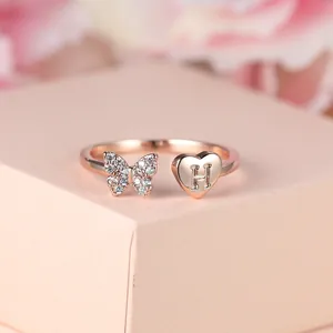 Détail d'une bague papillon or rose avec cœur en diamant et lettre H gravée