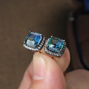Macro detail of square gradient tourmaline studs with pavé diamonds in dark gold finish