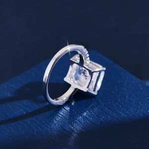 Luxe 5 karaat prinses geslepen moissanite ring met sprankelende zijstenen op blauw leer