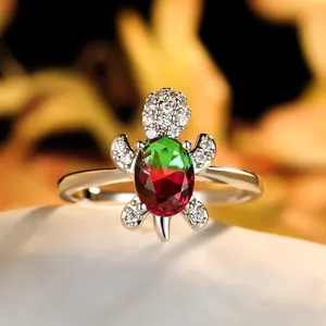 Detailed close-up of a silver turtle ring featuring bicolor emerald and ruby gemstones