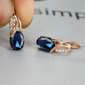 Detailed macro view of rose gold hoop earrings with oval navy blue cubic zirconia