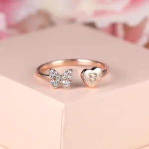 Détail de la bague en or rose avec papillon en cristal et cœur avec la lettre R