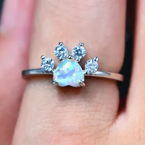 Detalle macro de un anillo de plata con ópalo corazón y diseño de huella de gato
