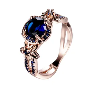 Anillo vintage de oro rosa con gema azul ovalada y diseño floral de filigrana