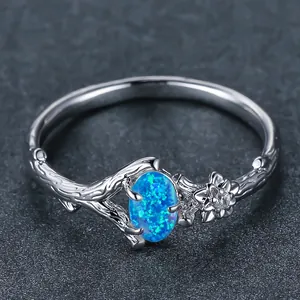Anello con opale blu ovale e fascia a forma di vite argentata con piccolo fiore decorativo