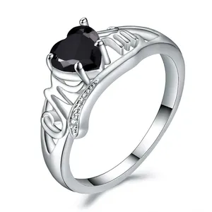 Macro detail of silver ring featuring heart-shaped black stone and MOM lettering