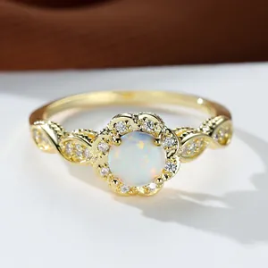 Macro shot of vintage gold flower ring with round white opal and filigree lace band